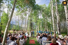 A Steamboat Springs, Colorado, wedding photo shows a couple exchanging vows among aspen trees.